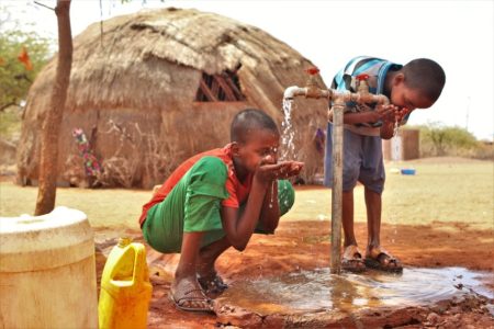 Niños bebiendo agua de la fuente