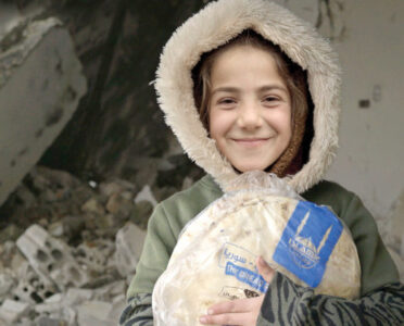 Niña siria sosteniendo pan en gracias a tu Zakat